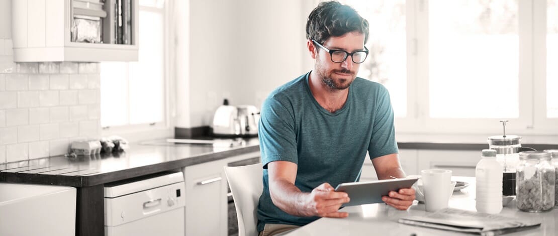 Man at kitchen table with tablet