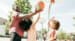 father and children playing basketball