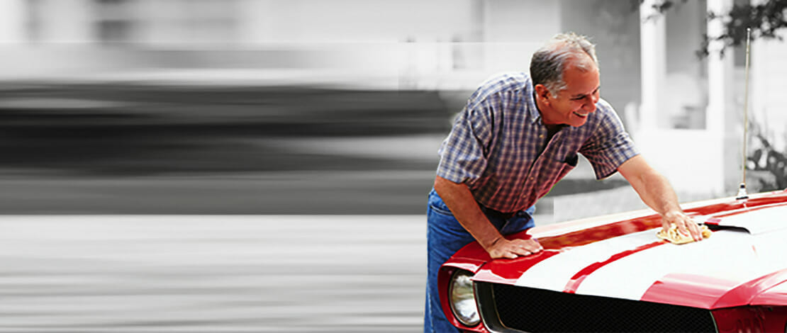 man waxing his car